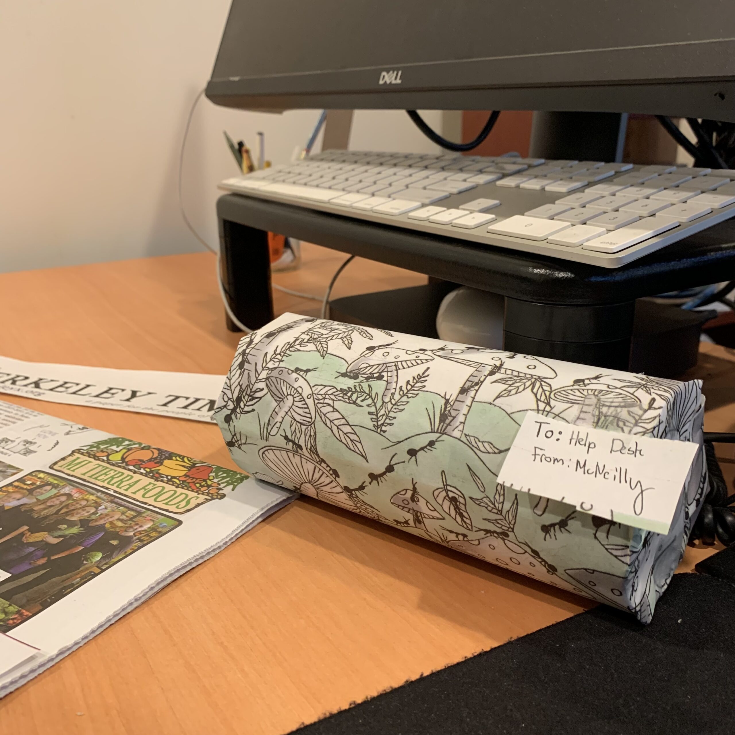 a cylindrical container wrapped in newspaper. It is labeled "to: Help Desk from: McNeilly"